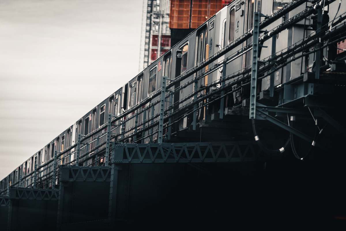 shipping container gray train under gray clouds at daytime metro
